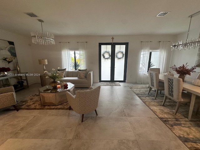 living room featuring french doors and an inviting chandelier