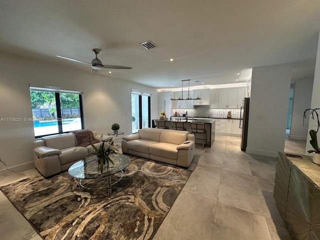 living room with ceiling fan and light tile patterned floors