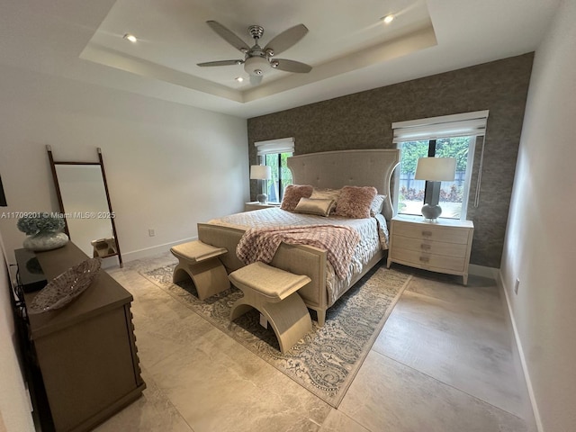 bedroom featuring a raised ceiling and ceiling fan