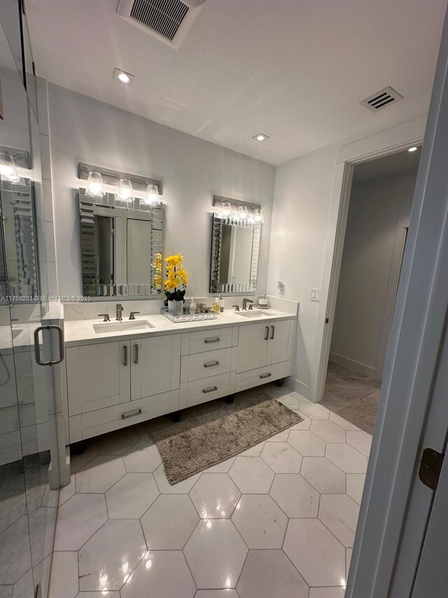 bathroom with a tile shower and vanity