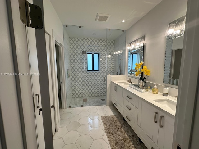 bathroom featuring tiled shower, vanity, and tile patterned flooring