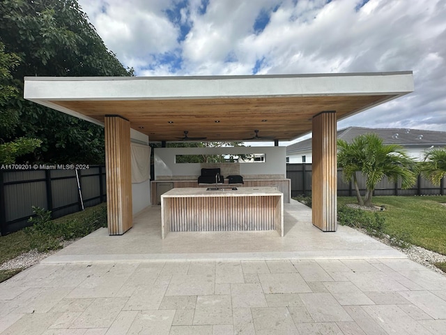 view of patio with a gazebo, ceiling fan, and an outdoor kitchen