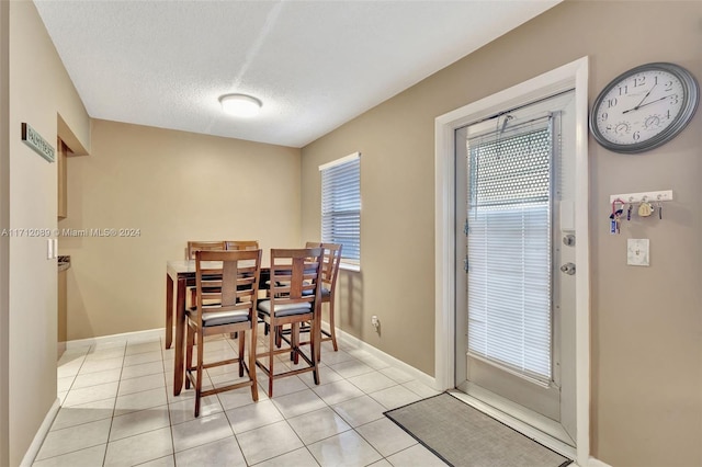 dining space featuring light tile patterned flooring and a textured ceiling