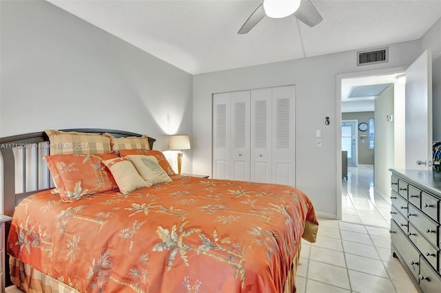 tiled bedroom with ceiling fan and a closet