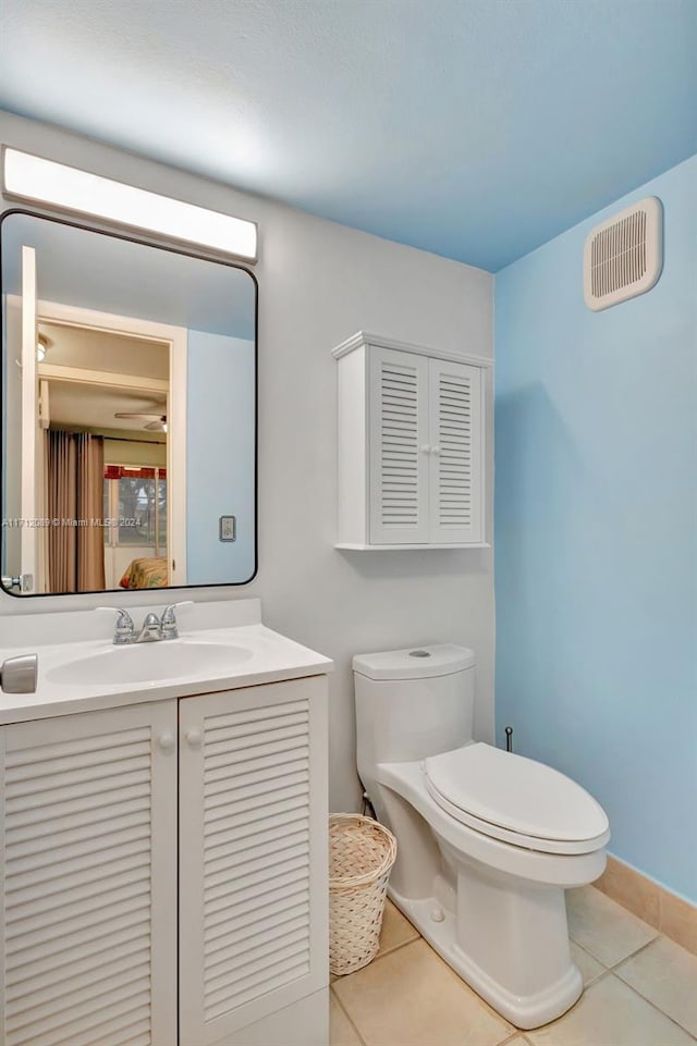 bathroom with tile patterned flooring, vanity, and toilet