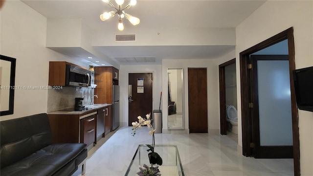 kitchen featuring an inviting chandelier, sink, appliances with stainless steel finishes, and tasteful backsplash