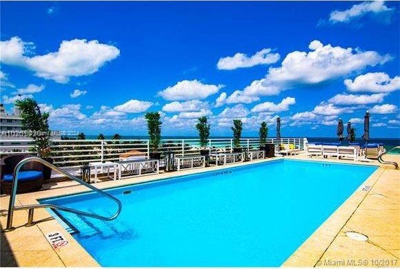 view of pool with a water view and a patio