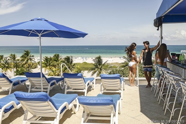 view of patio with a water view and a view of the beach