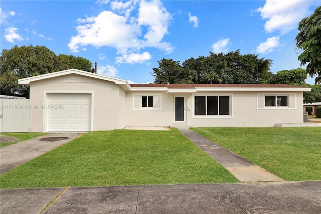 ranch-style house featuring a garage and a front lawn