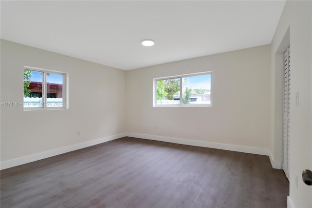 unfurnished bedroom featuring dark hardwood / wood-style flooring and multiple windows