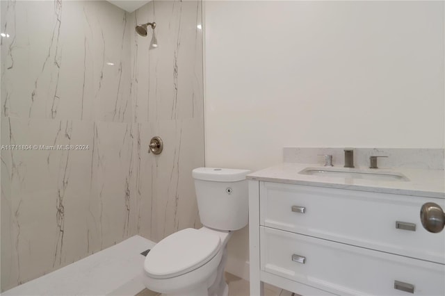 bathroom featuring vanity, toilet, and a tile shower