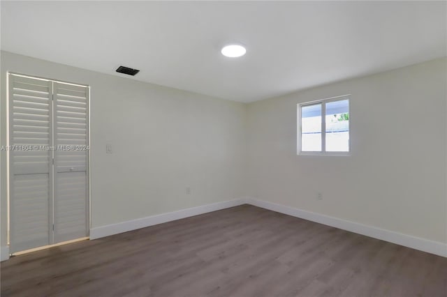 unfurnished bedroom featuring dark hardwood / wood-style flooring and a closet