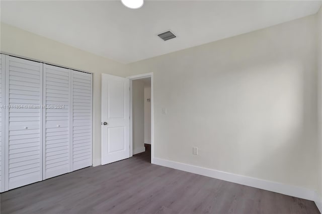 unfurnished bedroom with hardwood / wood-style floors and a closet