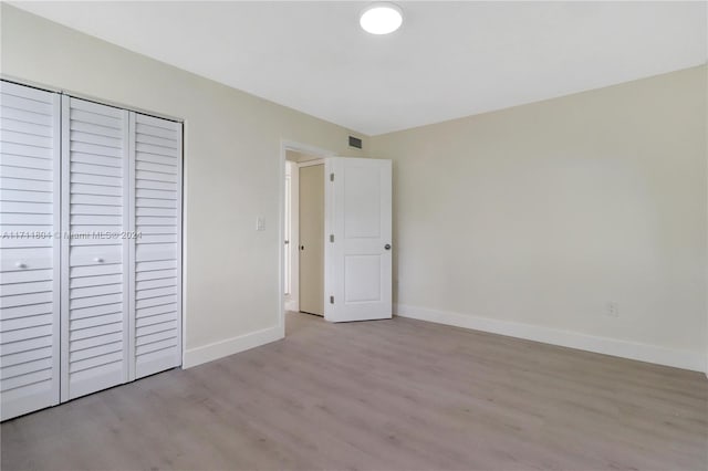 unfurnished bedroom featuring light wood-type flooring and a closet