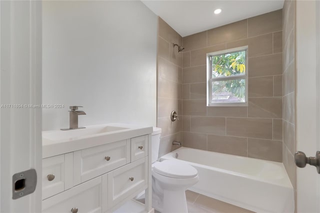 full bathroom with tile patterned floors, tiled shower / bath, vanity, and toilet