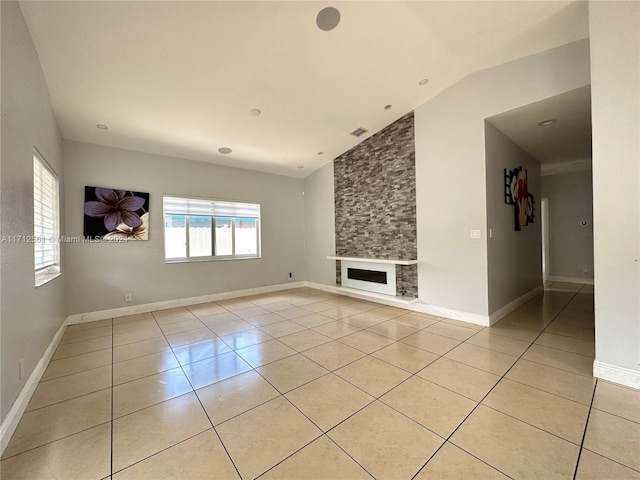 unfurnished living room featuring a large fireplace, light tile patterned flooring, and vaulted ceiling