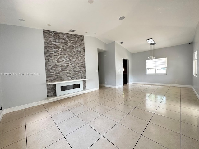 unfurnished living room featuring a large fireplace, light tile patterned flooring, vaulted ceiling, and an inviting chandelier