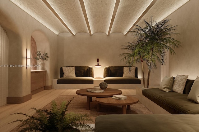 living room with vaulted ceiling, brick ceiling, and light hardwood / wood-style flooring