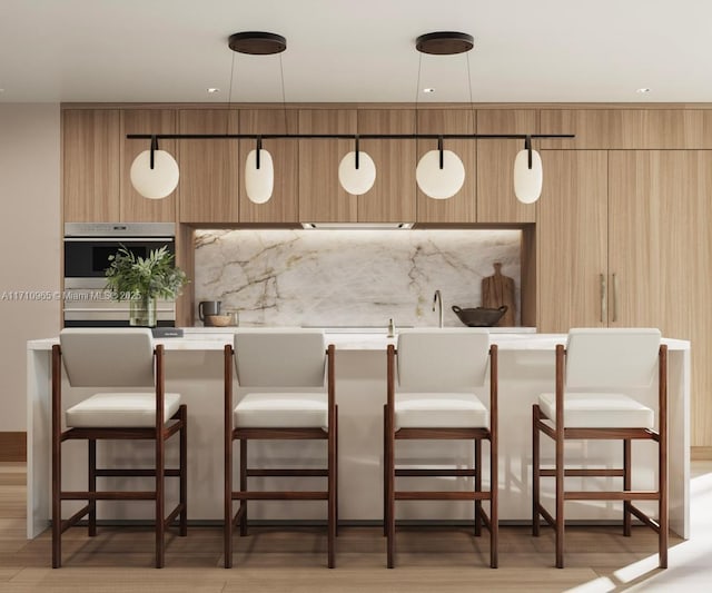 bar featuring decorative light fixtures, stainless steel oven, and light hardwood / wood-style flooring