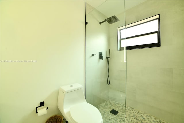 bathroom with toilet and tiled shower