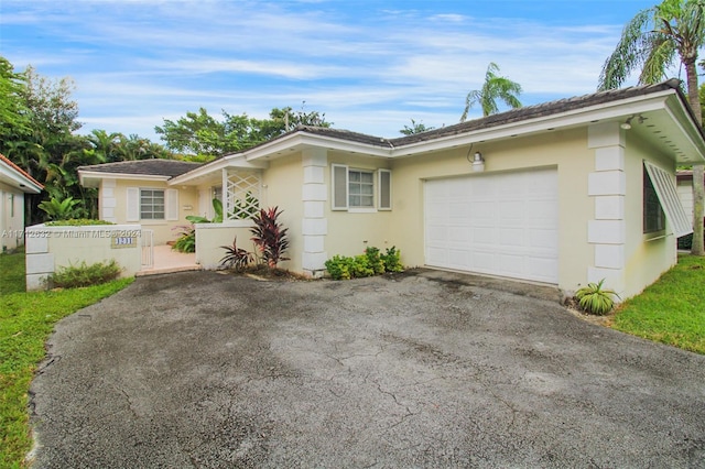 4241 Red Rd, Coral Gables, FL 33134 - ranch-style house with an attached garage, driveway, and stucco siding