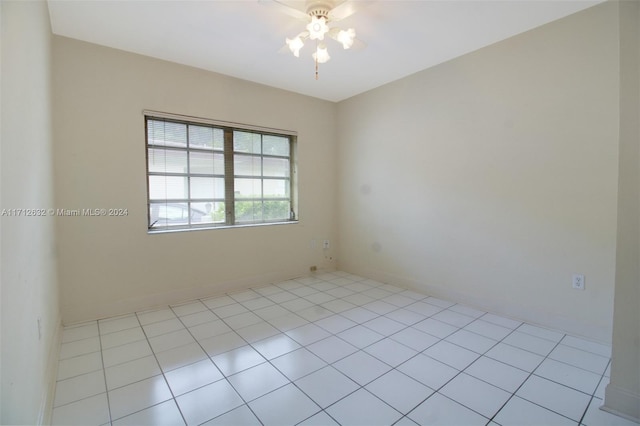 empty room with ceiling fan and light tile patterned floors