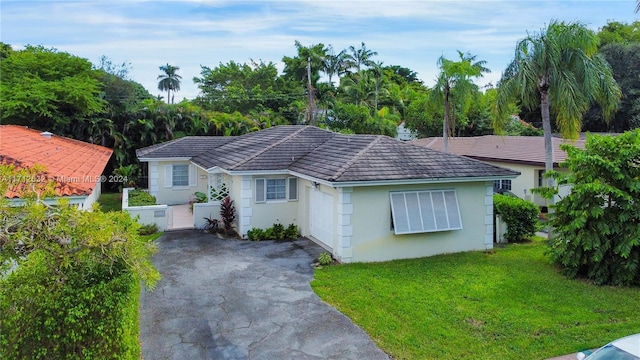 single story home featuring a garage and a front yard