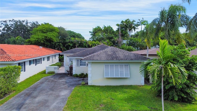 4241 Red Rd, Coral Gables, FL 33134 - view of front of house with stucco siding, a front lawn, and asphalt driveway