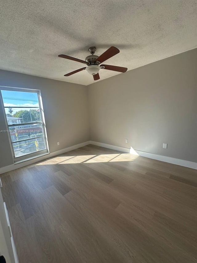 unfurnished room featuring ceiling fan, hardwood / wood-style floors, and a textured ceiling