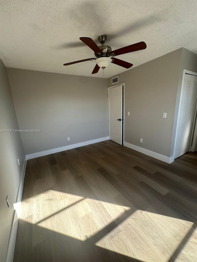 empty room featuring dark wood-type flooring and a textured ceiling