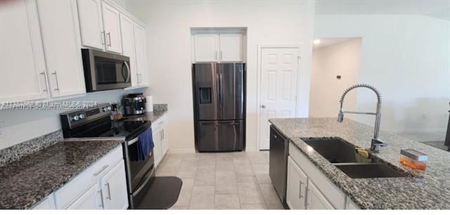 kitchen with white cabinetry, sink, dark stone counters, light hardwood / wood-style floors, and black appliances