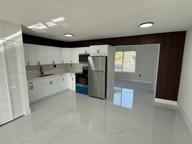 kitchen with white cabinetry, sink, a textured ceiling, and appliances with stainless steel finishes