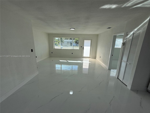 unfurnished room with a textured ceiling