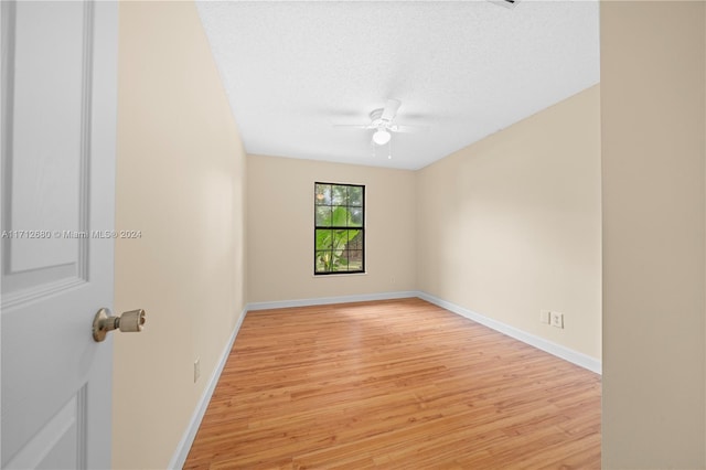 spare room with a textured ceiling, light hardwood / wood-style floors, and ceiling fan