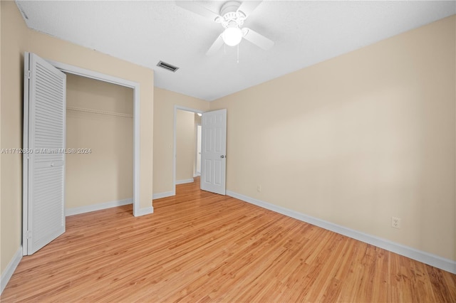 unfurnished bedroom with ceiling fan, light hardwood / wood-style floors, and a closet