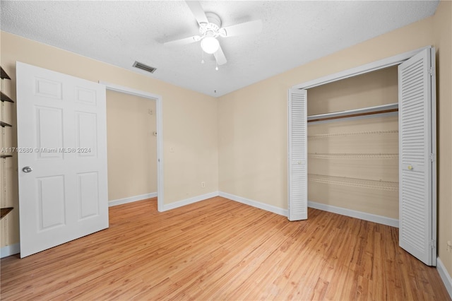 unfurnished bedroom with hardwood / wood-style flooring, ceiling fan, and a textured ceiling