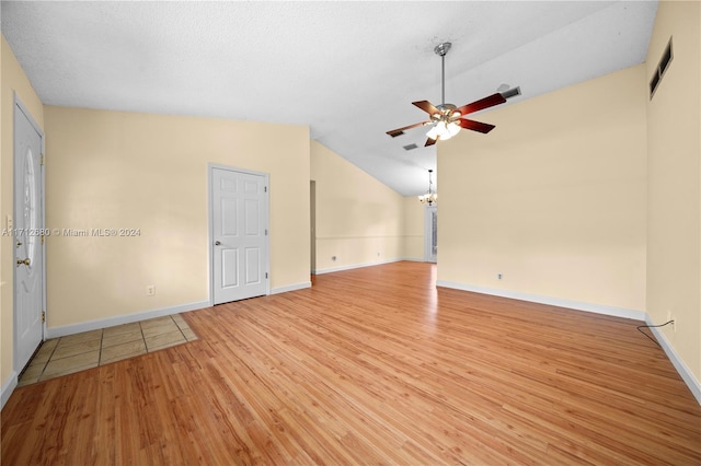 spare room featuring a textured ceiling, ceiling fan, vaulted ceiling, and light wood-type flooring