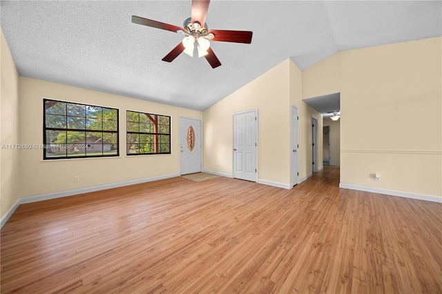 spare room featuring ceiling fan, light wood-type flooring, a textured ceiling, and vaulted ceiling