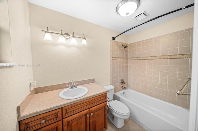 full bathroom featuring tile patterned flooring, vanity, toilet, and tiled shower / bath