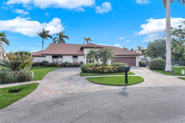 single story home featuring a front lawn and a garage