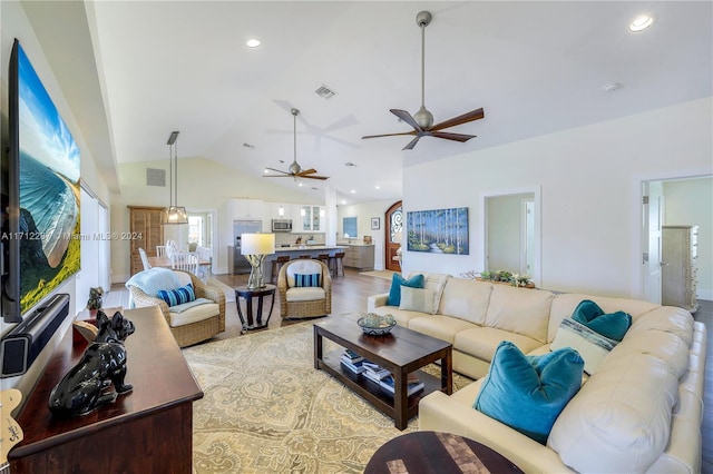 living room with ceiling fan, light hardwood / wood-style flooring, and vaulted ceiling