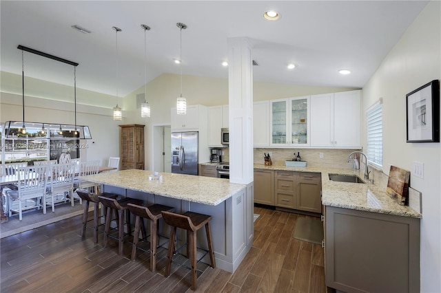 kitchen with white cabinetry, sink, a center island, dark wood-type flooring, and stainless steel appliances