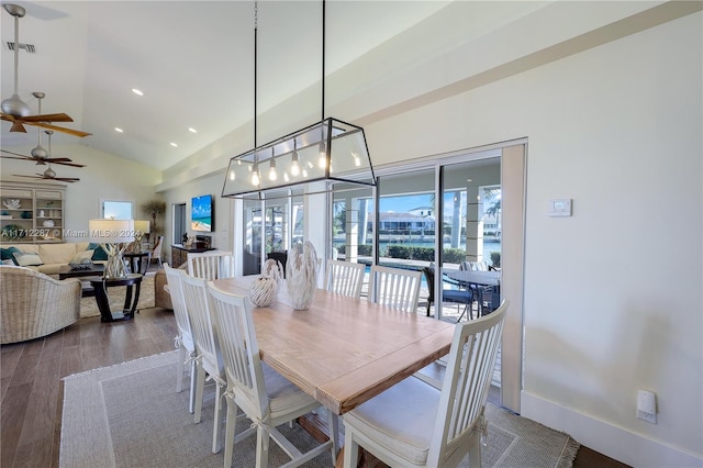 dining area with hardwood / wood-style floors and high vaulted ceiling