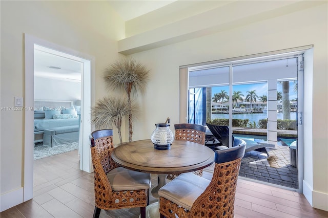 dining room with hardwood / wood-style flooring and a water view