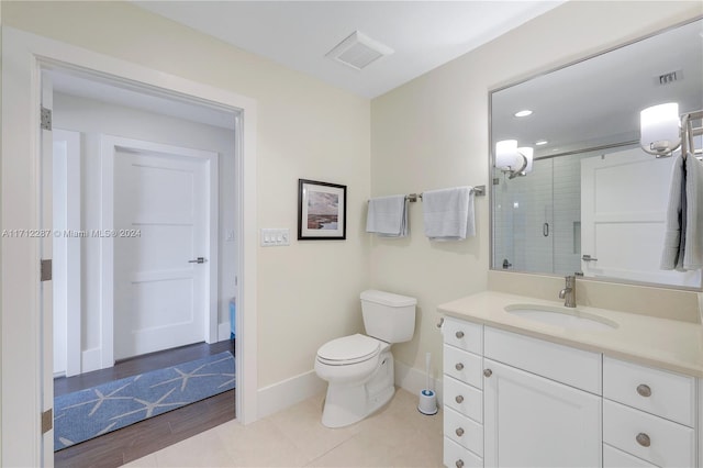 bathroom featuring vanity, toilet, wood-type flooring, and walk in shower