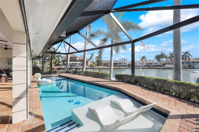 view of pool with glass enclosure, a water view, and a patio