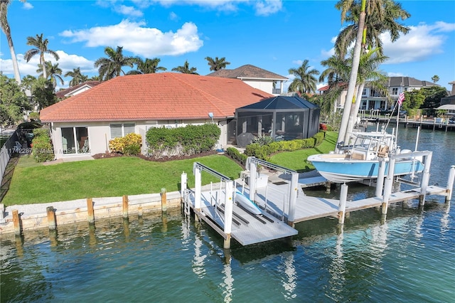 view of dock with a lanai, a water view, and a yard