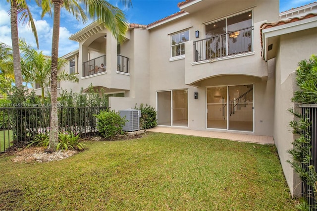 back of property featuring a yard and central AC