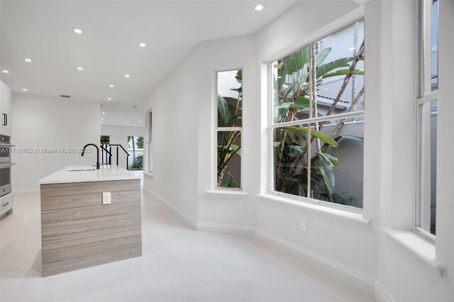 kitchen featuring light tile patterned floors and sink