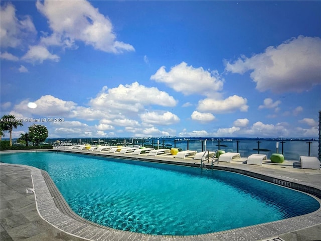 view of swimming pool featuring a patio area and a water view